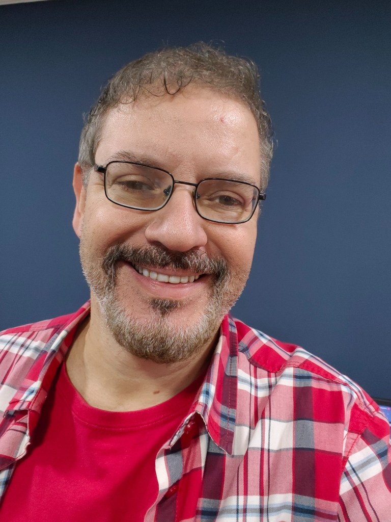 Professor Glaucio Aranha smiling in a work environment.