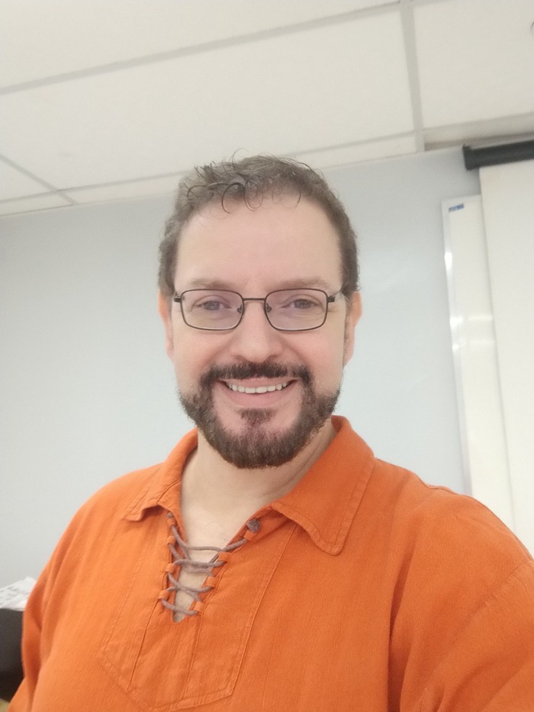 Professor Glaucio Aranha smiling in an academic environment.